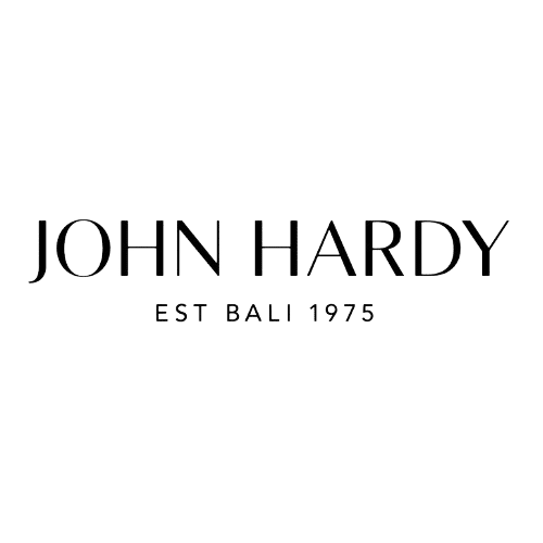 The image shows the logo of "John Hardy," a company established in Bali in 1975. The text, written in a stylish and elegant font, features "JOHN HARDY" prominently, with "EST BALI 1975" in smaller letters beneath it, evoking a sense of timeless craftsmanship that feels right at home.