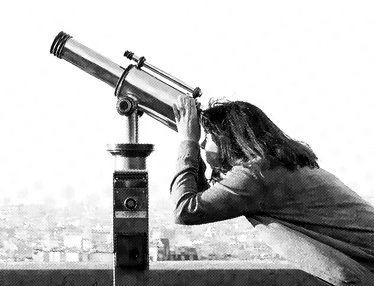 A monochrome image captures a person with medium-length hair approaching a large, mounted telescope. Positioned at an outdoor observation point, they gaze intently through the lens. The background remains blurred, emphasizing their focus on the celestial view.